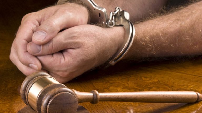 picture of a handcuffed man with gavel
